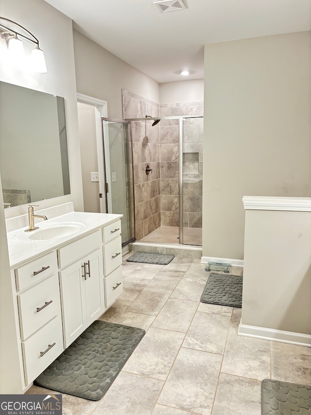 bathroom with vanity and a shower with door