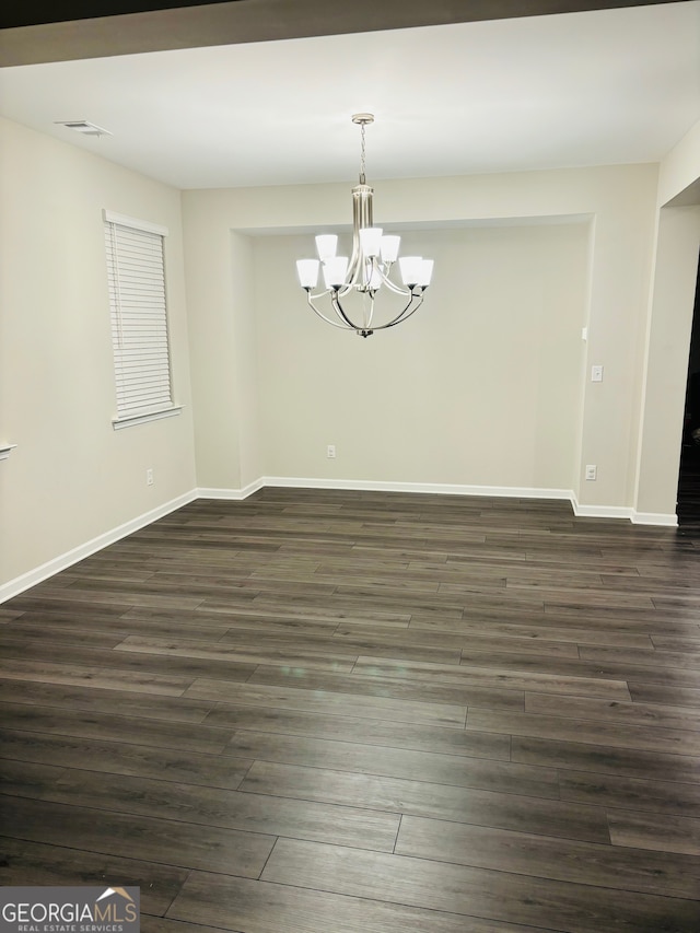 unfurnished dining area with a chandelier and dark wood-type flooring