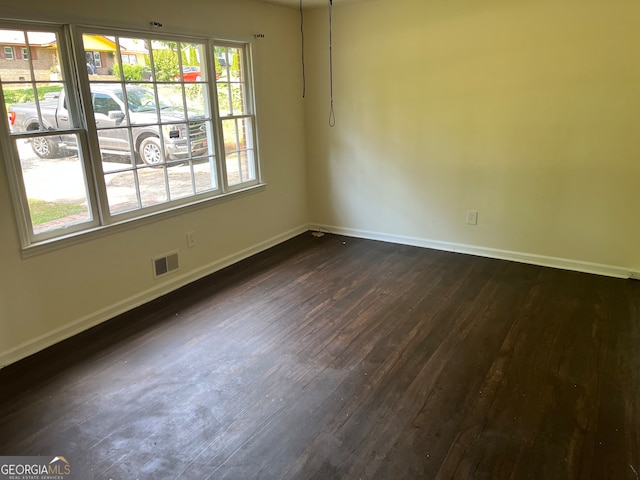 unfurnished room with dark wood-type flooring