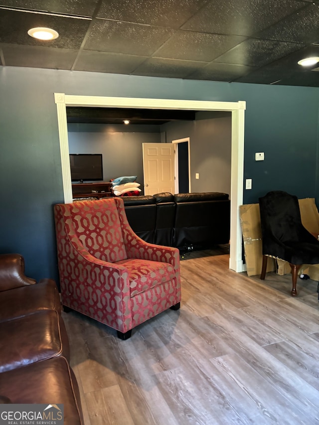 living area with hardwood / wood-style floors and a paneled ceiling