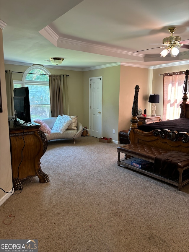 living room with a raised ceiling, ornamental molding, carpet, and ceiling fan