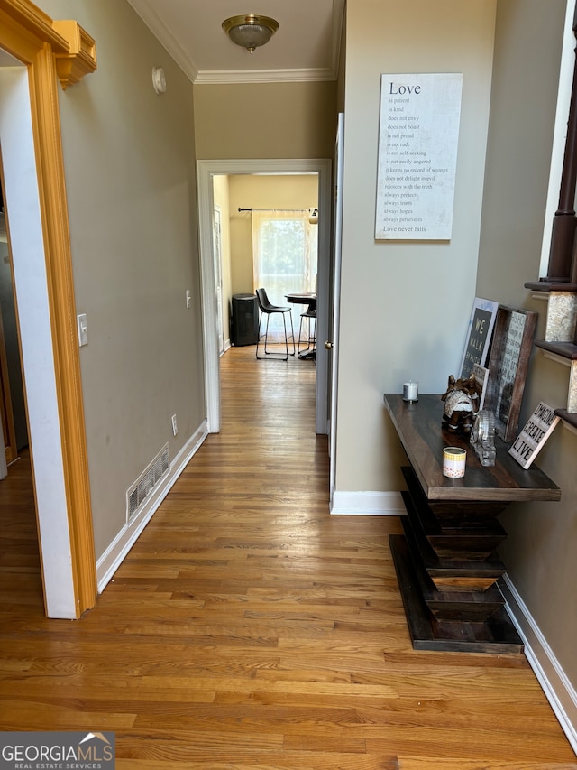 corridor with crown molding and light wood-type flooring