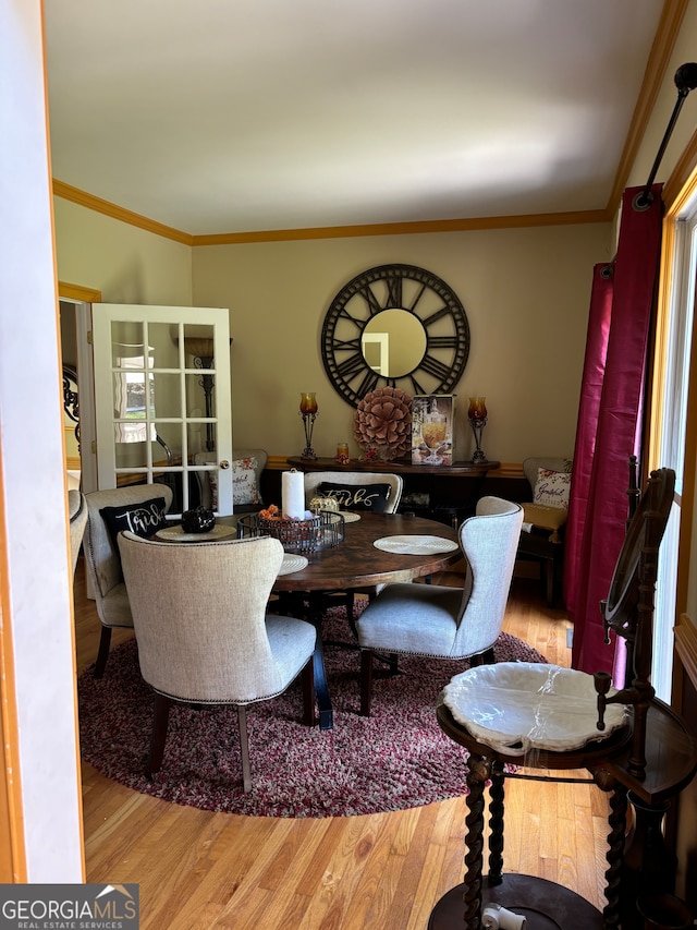 dining area with light hardwood / wood-style floors and ornamental molding