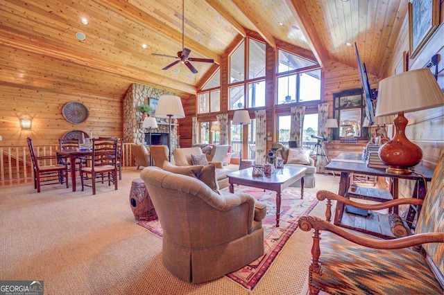 living room featuring high vaulted ceiling, a fireplace, beamed ceiling, ceiling fan, and light carpet