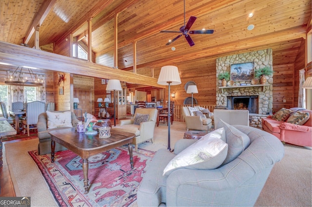 living room with ceiling fan, wood walls, a stone fireplace, high vaulted ceiling, and wooden ceiling