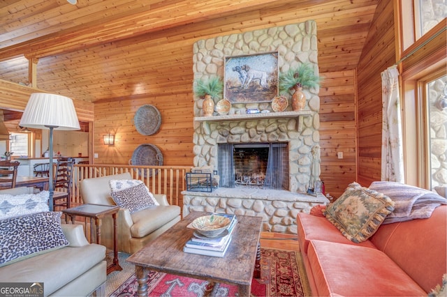 living room featuring wooden walls, hardwood / wood-style flooring, wooden ceiling, and a stone fireplace