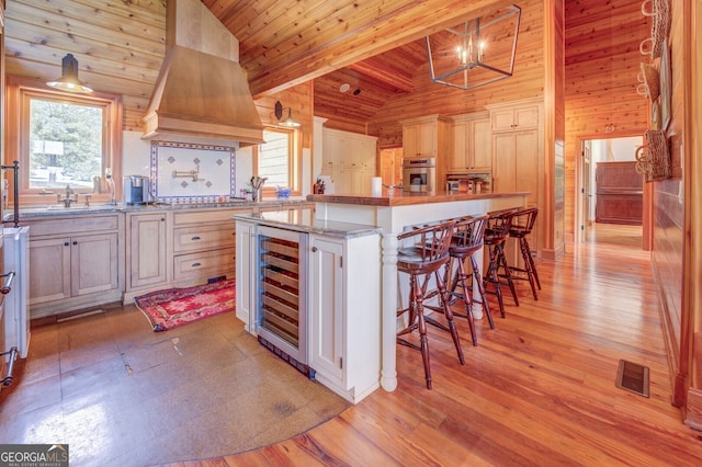 kitchen featuring wood walls, a kitchen island, vaulted ceiling with beams, oven, and wooden ceiling