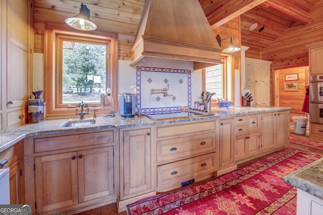 kitchen featuring pendant lighting, wooden ceiling, premium range hood, wooden walls, and sink