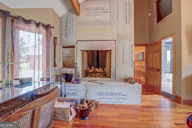 interior space with light wood-type flooring and lofted ceiling with beams