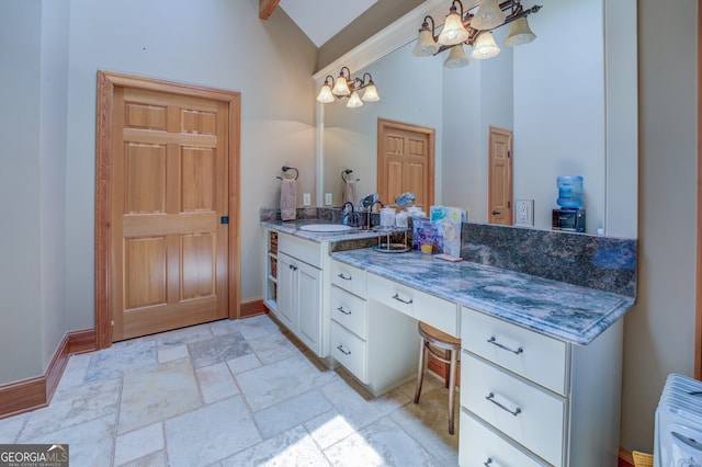 bathroom featuring vanity, a chandelier, and high vaulted ceiling