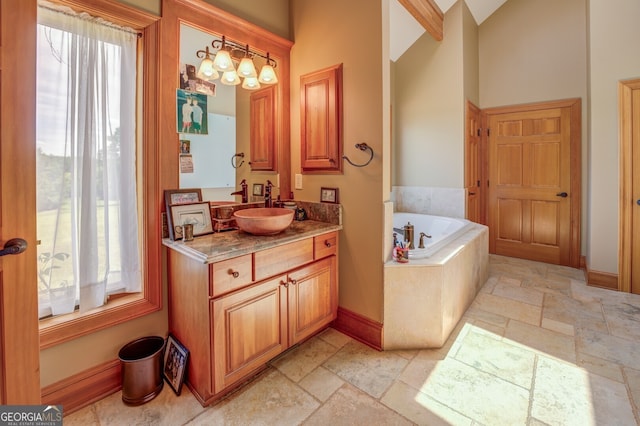 bathroom featuring tiled tub and vanity