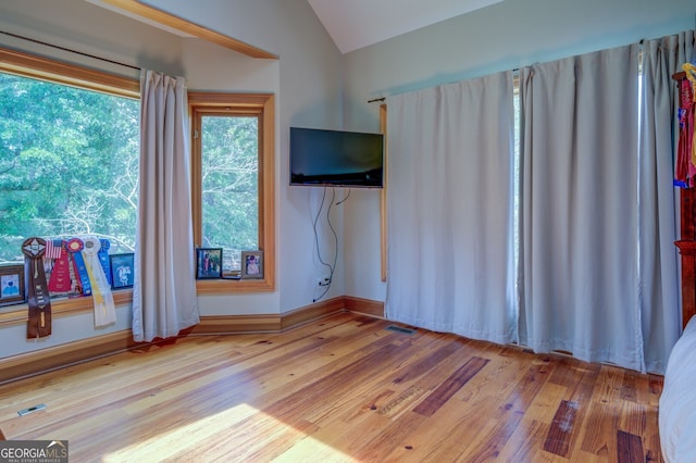 empty room featuring light wood-type flooring and lofted ceiling