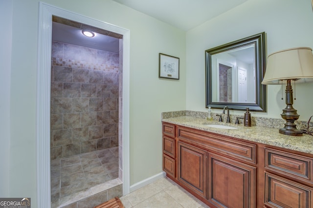 bathroom featuring a tile shower, vanity, and tile patterned floors