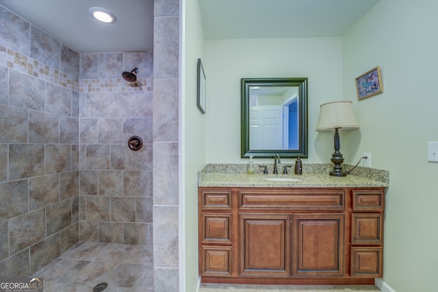 bathroom featuring vanity and tiled shower