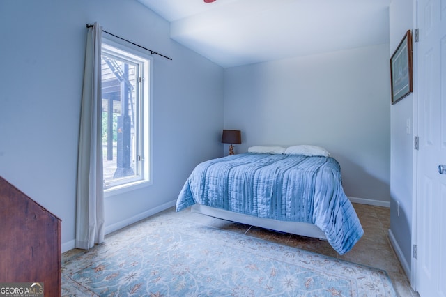 bedroom featuring multiple windows and lofted ceiling