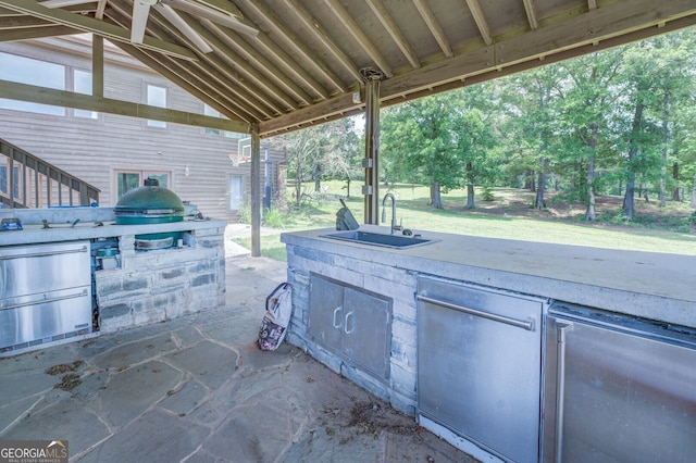 view of patio with a grill, area for grilling, beverage cooler, and sink