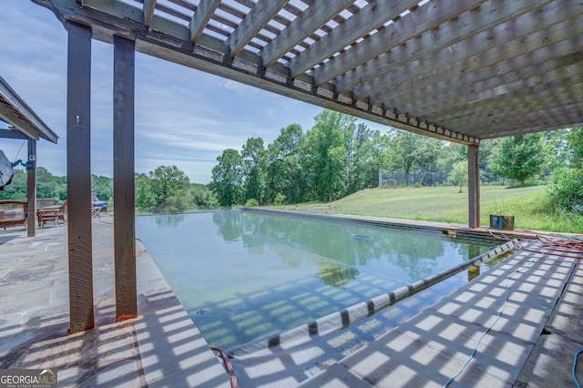 view of swimming pool with a pergola, a yard, and a water view