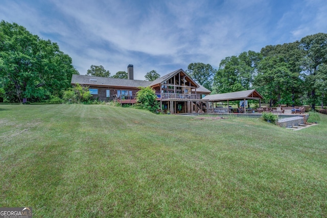 back of property featuring a wooden deck and a lawn