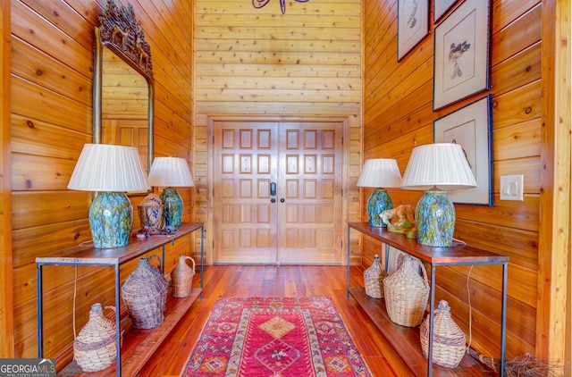 foyer entrance featuring wood-type flooring and wooden walls