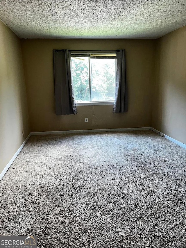 empty room featuring carpet floors and a textured ceiling