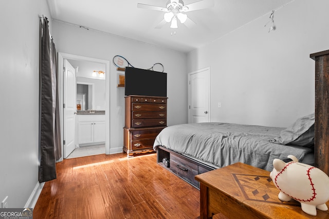 bedroom with ceiling fan, light wood-type flooring, and ensuite bath