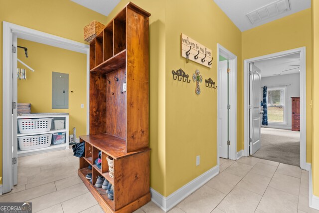 mudroom with electric panel and light tile patterned flooring