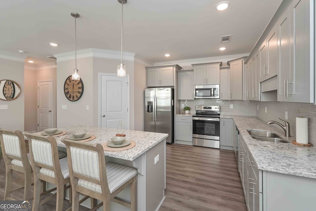 kitchen featuring pendant lighting, sink, stainless steel appliances, dark hardwood / wood-style flooring, and decorative backsplash