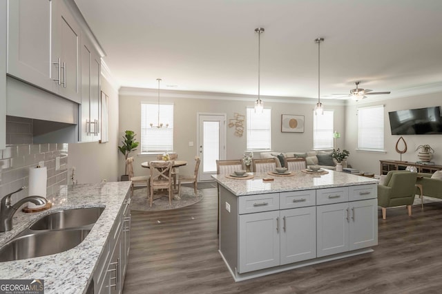 kitchen featuring decorative light fixtures, ceiling fan with notable chandelier, sink, and a healthy amount of sunlight