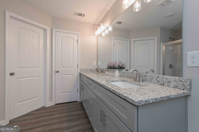 bathroom with vanity, an enclosed shower, and hardwood / wood-style flooring