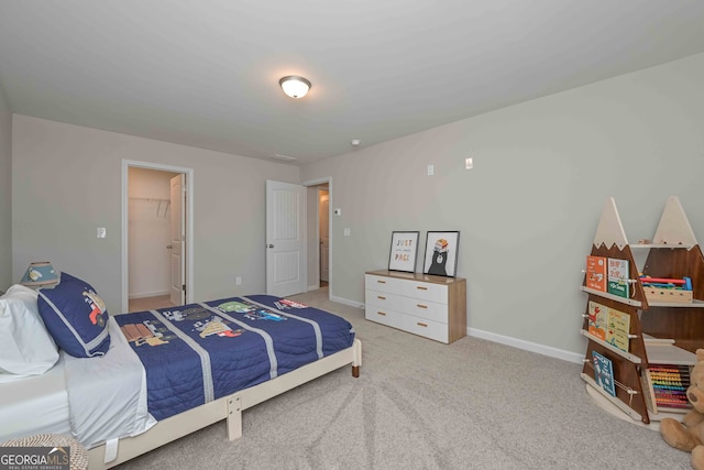 carpeted bedroom with a closet and a walk in closet