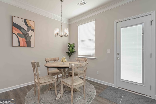 dining room featuring ornamental molding, dark hardwood / wood-style floors, and a chandelier