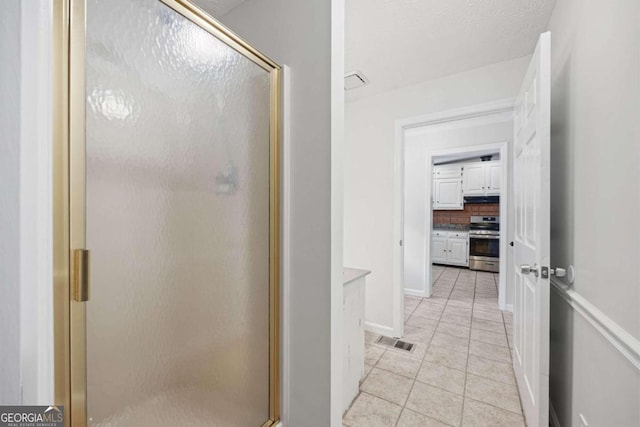 bathroom with walk in shower, tile patterned flooring, and tasteful backsplash