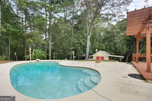 view of pool with an outdoor structure, a patio area, and a diving board