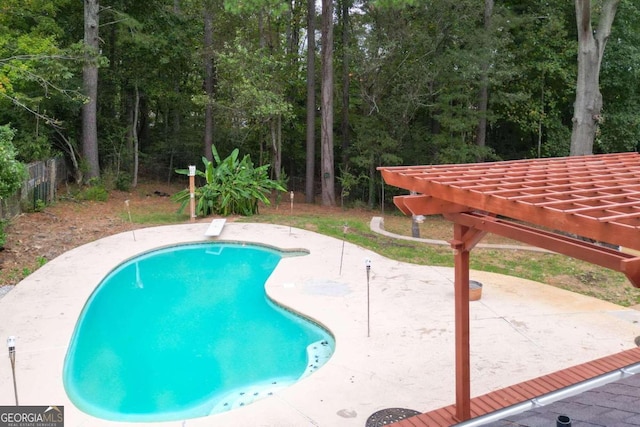 view of pool with a patio and a diving board