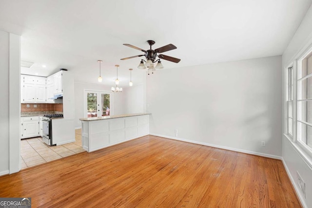 unfurnished living room featuring light wood-type flooring, ceiling fan, and french doors