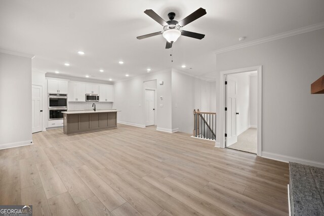 unfurnished room featuring crown molding, light colored carpet, and ceiling fan