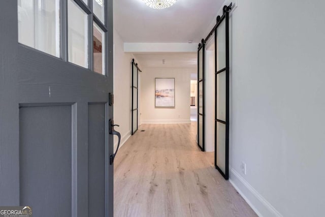 hallway featuring light hardwood / wood-style flooring and a barn door