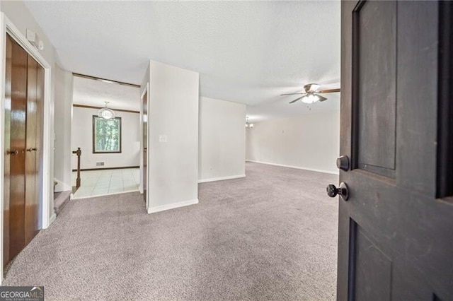 spare room with ceiling fan, a textured ceiling, and carpet flooring