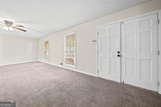 unfurnished bedroom featuring carpet floors, a textured ceiling, and ceiling fan