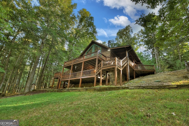 rear view of house with a wooden deck and a yard