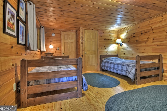 bedroom featuring light hardwood / wood-style flooring, wooden walls, and wooden ceiling