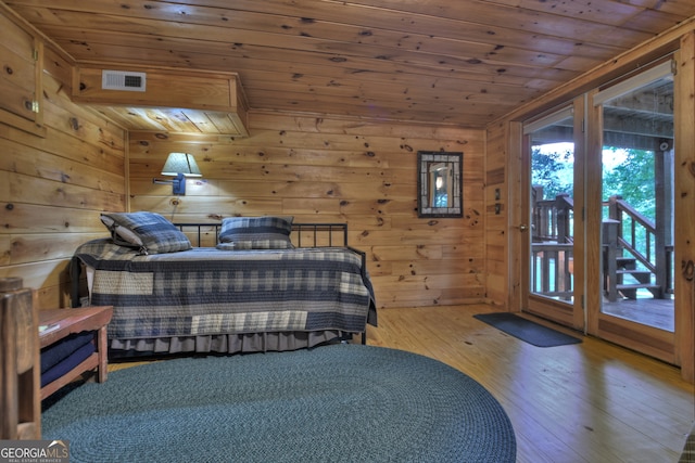 bedroom featuring access to outside, wooden walls, hardwood / wood-style floors, and wooden ceiling