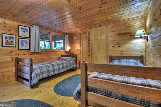 bedroom with wooden walls, light hardwood / wood-style floors, and wood ceiling