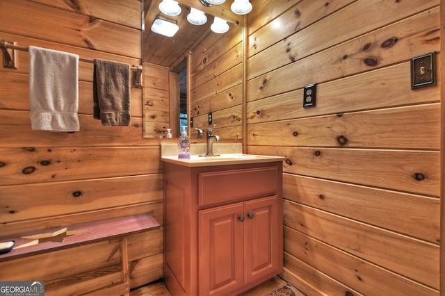 bathroom featuring wood walls and vanity