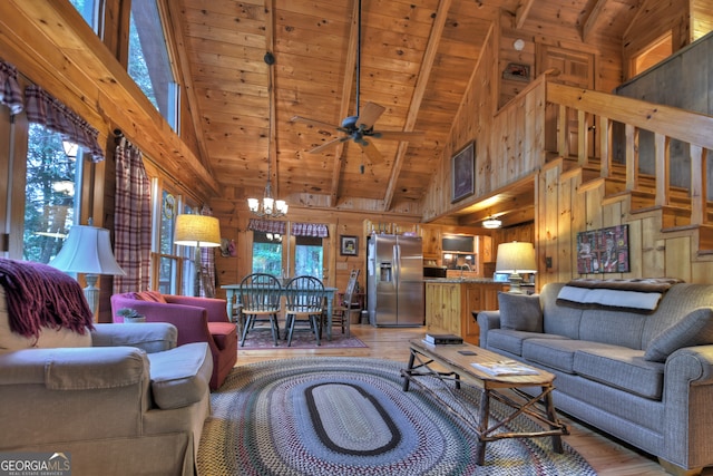 living room featuring wood ceiling, wooden walls, high vaulted ceiling, ceiling fan with notable chandelier, and hardwood / wood-style floors