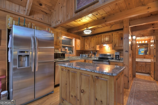 kitchen featuring sink, beam ceiling, a kitchen island, appliances with stainless steel finishes, and light hardwood / wood-style floors