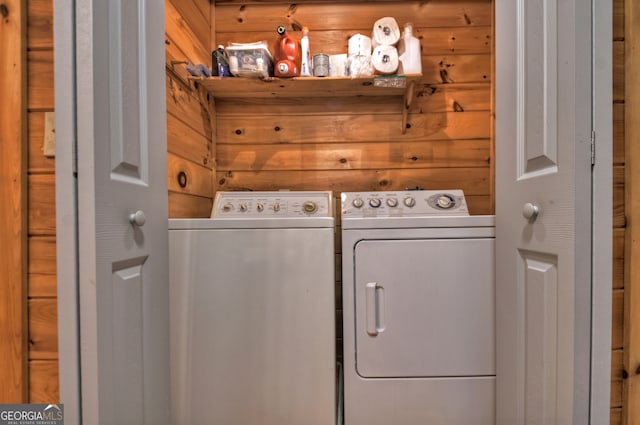 laundry room with washer and clothes dryer and wood walls