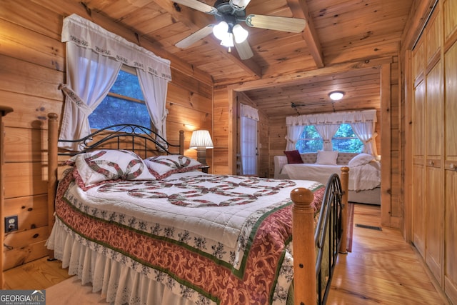 bedroom featuring light wood-type flooring, ceiling fan, wooden ceiling, and wooden walls