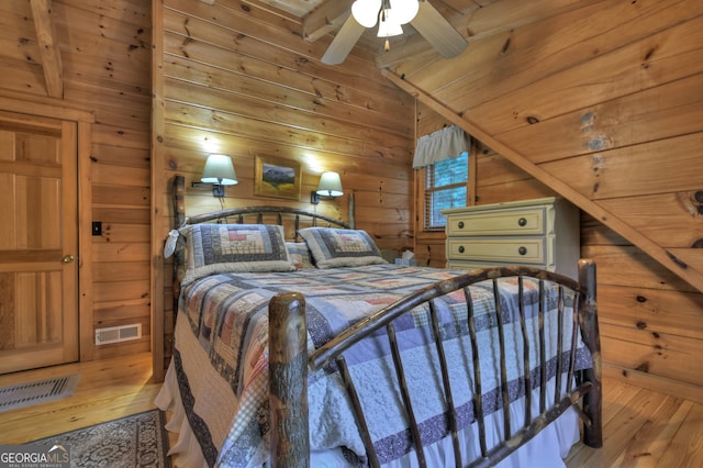 bedroom with light hardwood / wood-style floors, wood walls, wooden ceiling, lofted ceiling, and ceiling fan