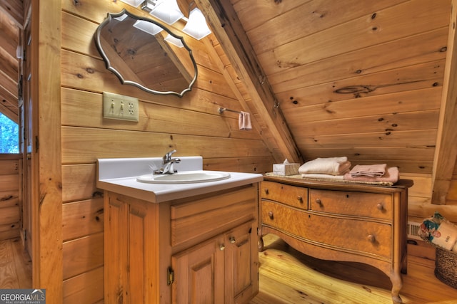 bathroom with vanity, lofted ceiling, wood ceiling, wood-type flooring, and wooden walls